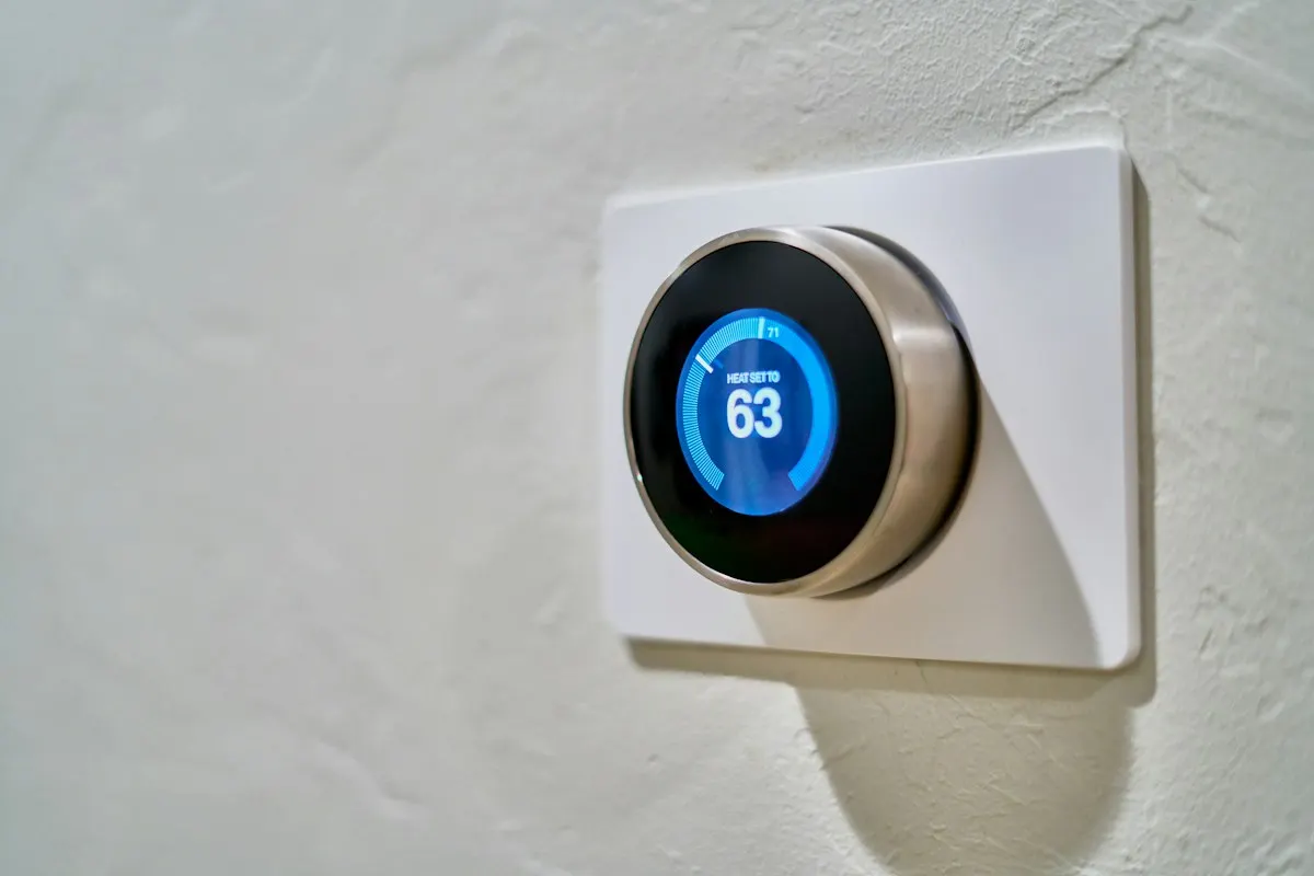 Round digital thermostat mounted on a white wall